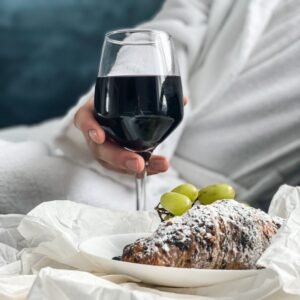 Elegant breakfast setting with a croissant and red wine, ideal for a luxurious start to the day.