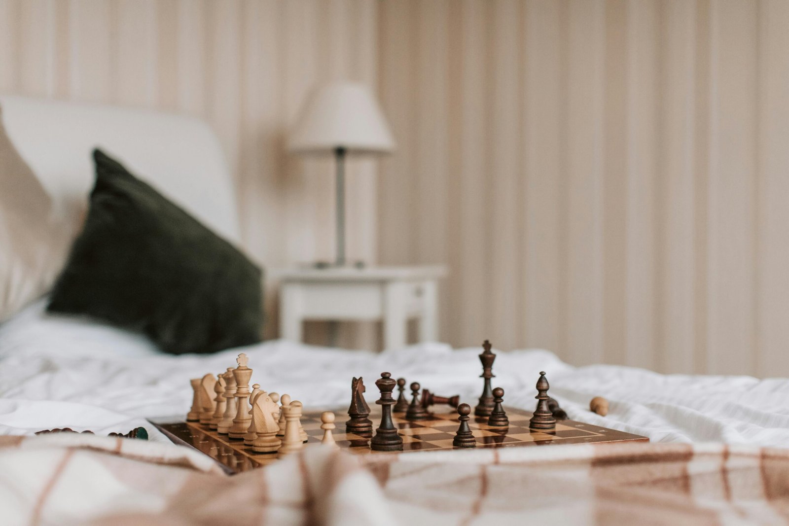 A cozy indoor setting with a chessboard on a bed, offering a peaceful and strategic atmosphere.